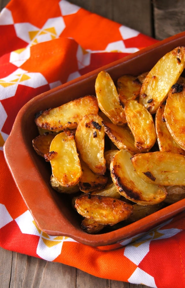 Crispy sliced, fingerling potatoes in a rectangular, terra cotta dish.