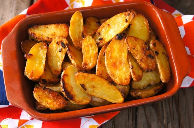 Top view of Crispy Onion Fingerling Potatoes in a rectangular terra cotta dish.