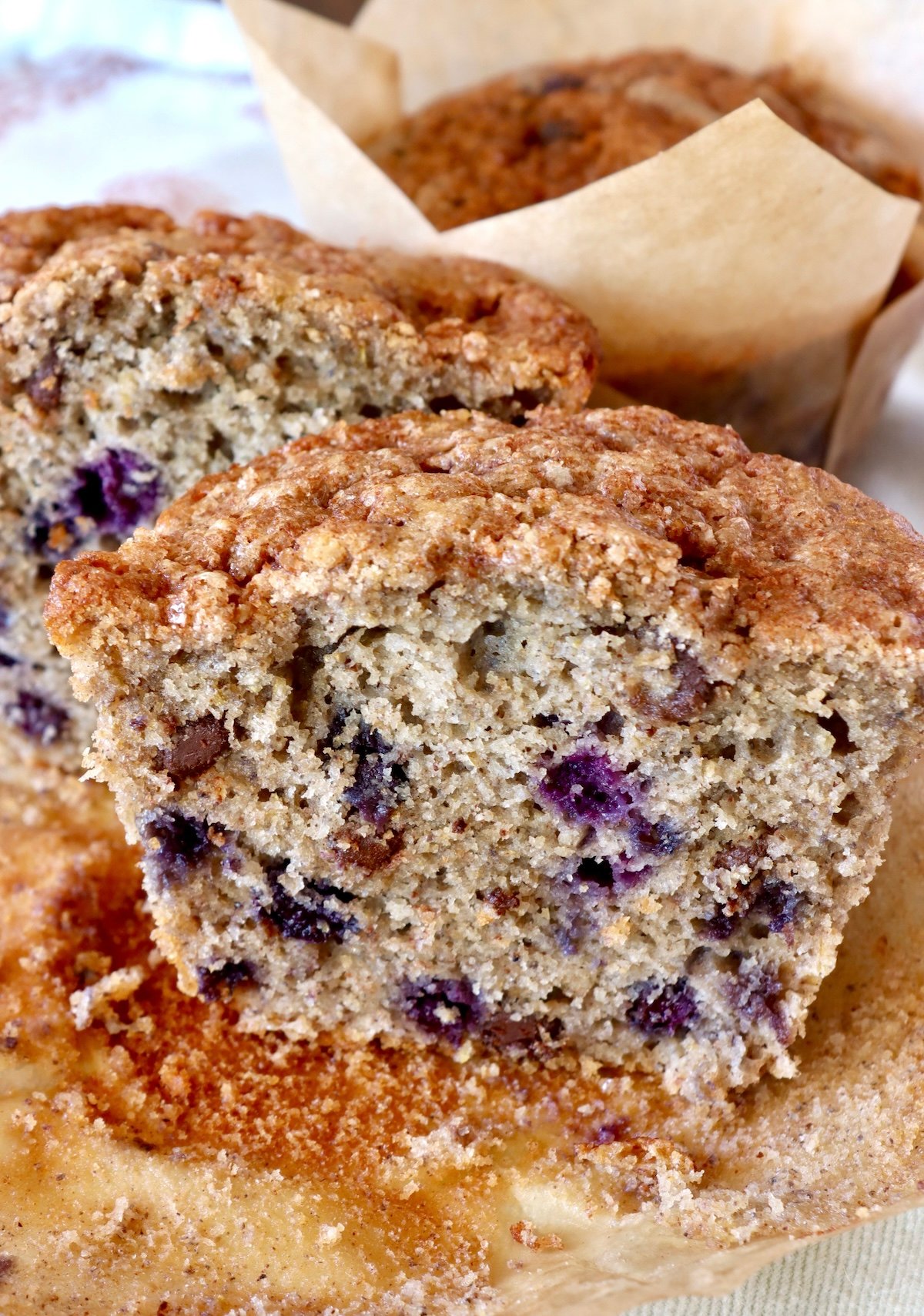 Close up of one large blueberry chocolate chip muffin cut in half.