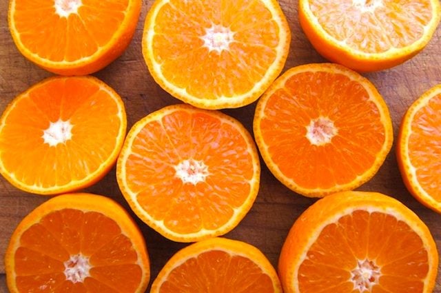 several oranges sliced in half on cutting board