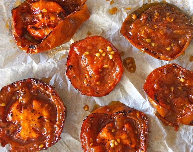 Several smoky Grilled Tomatoes on parchment paper