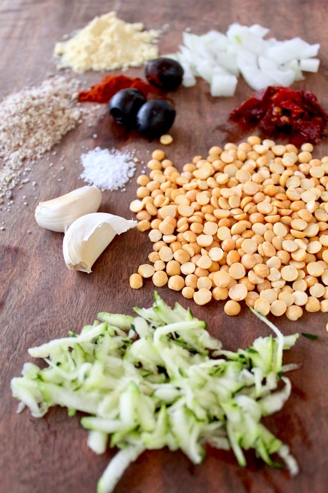 dry yellow peas, grated zucchini, garlic, onion and flours on cutting board for veggie burgers