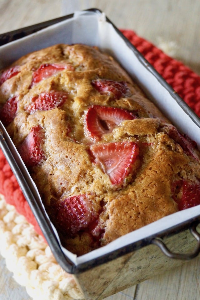 Baked Rosemary-Strawberry Cake in loaf pan, right out of oven on hot pads.