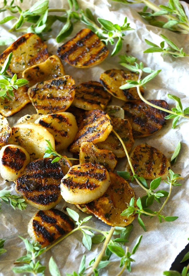Herb Grilled Elephant Garlic with fresh thyme on parchment paper.