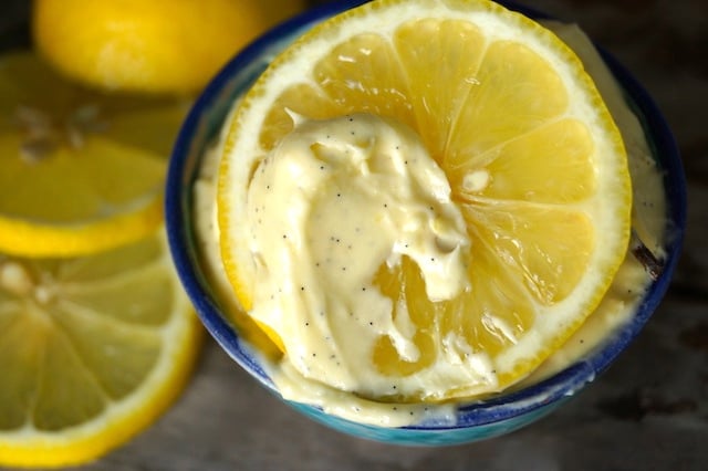 Whipped Lemon-Vanilla Butter in a blue-rimmed bowl with lemon slices in the background.
