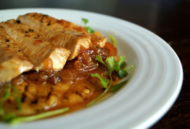 Sliced Sweet and Spicy Grilled Pineapple Pork Chop on a white plate