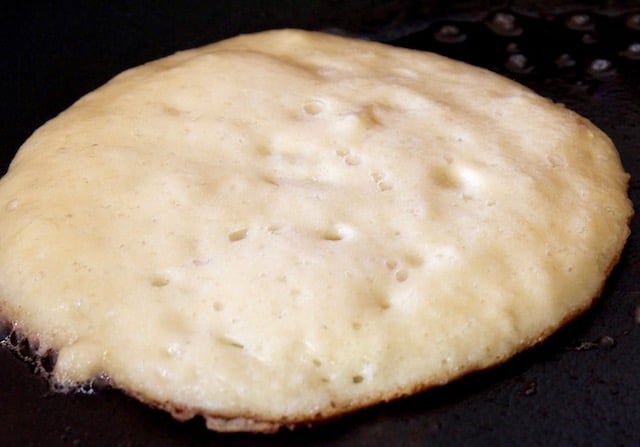 coconut flour pancake in pan with only bottom side cooked