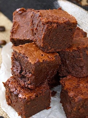 Stack of square cut coffee brownies on a burlap bag.