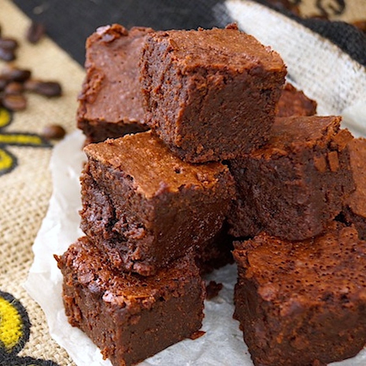 Stack of square cut coffee brownies on a burlap bag.