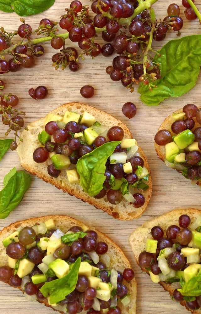 Bruschetta with Champagne Grapes on a light wood surface