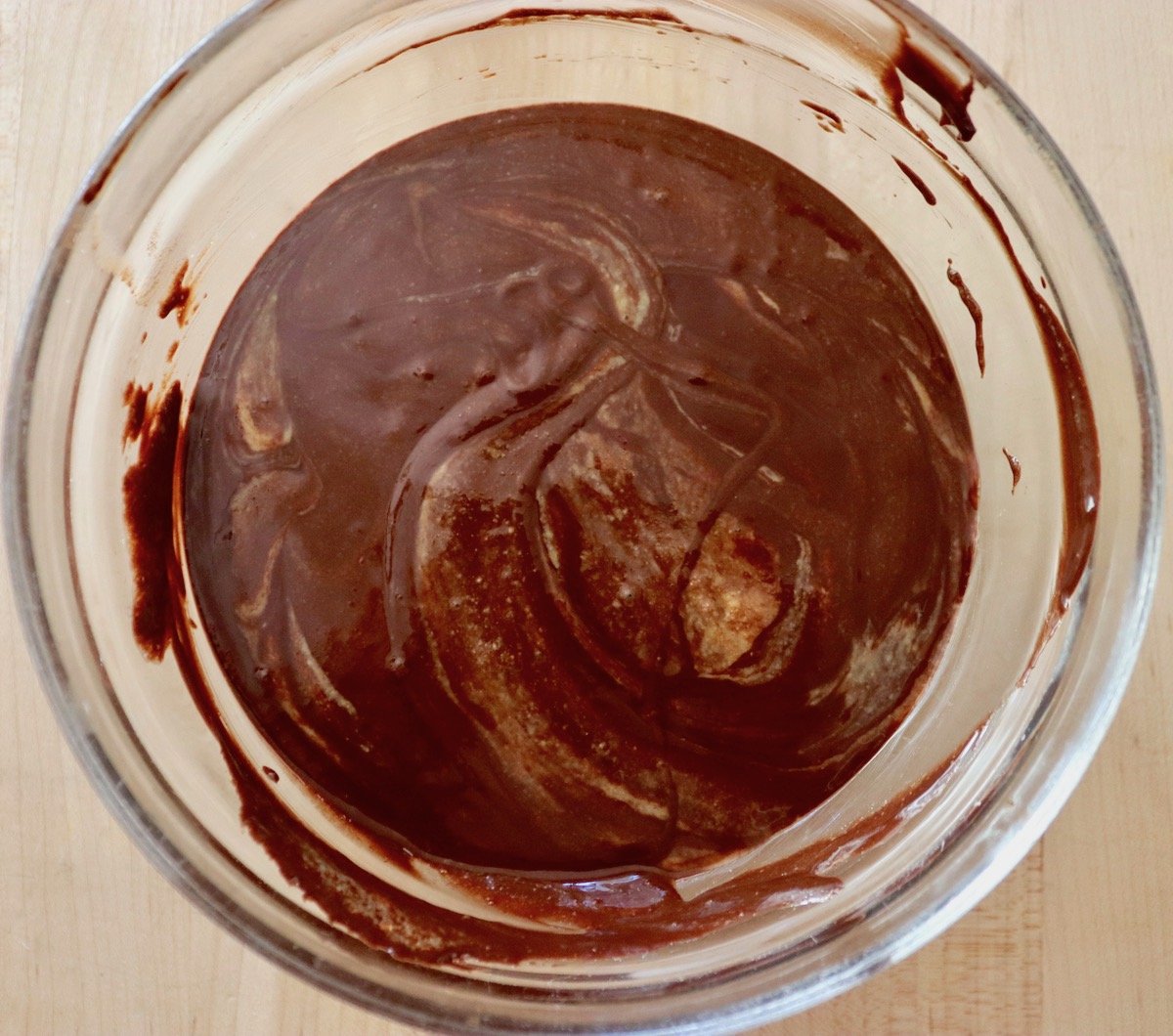Mixture of chocolate ganache and sesame paste in a glass bowl.