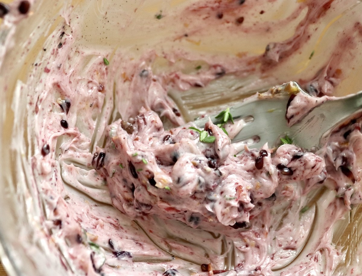 Blackberry-Chicken-Recipe-with-Blackberry-Butter) Small glass bowl with mixture of blackberries and butter with a fork.