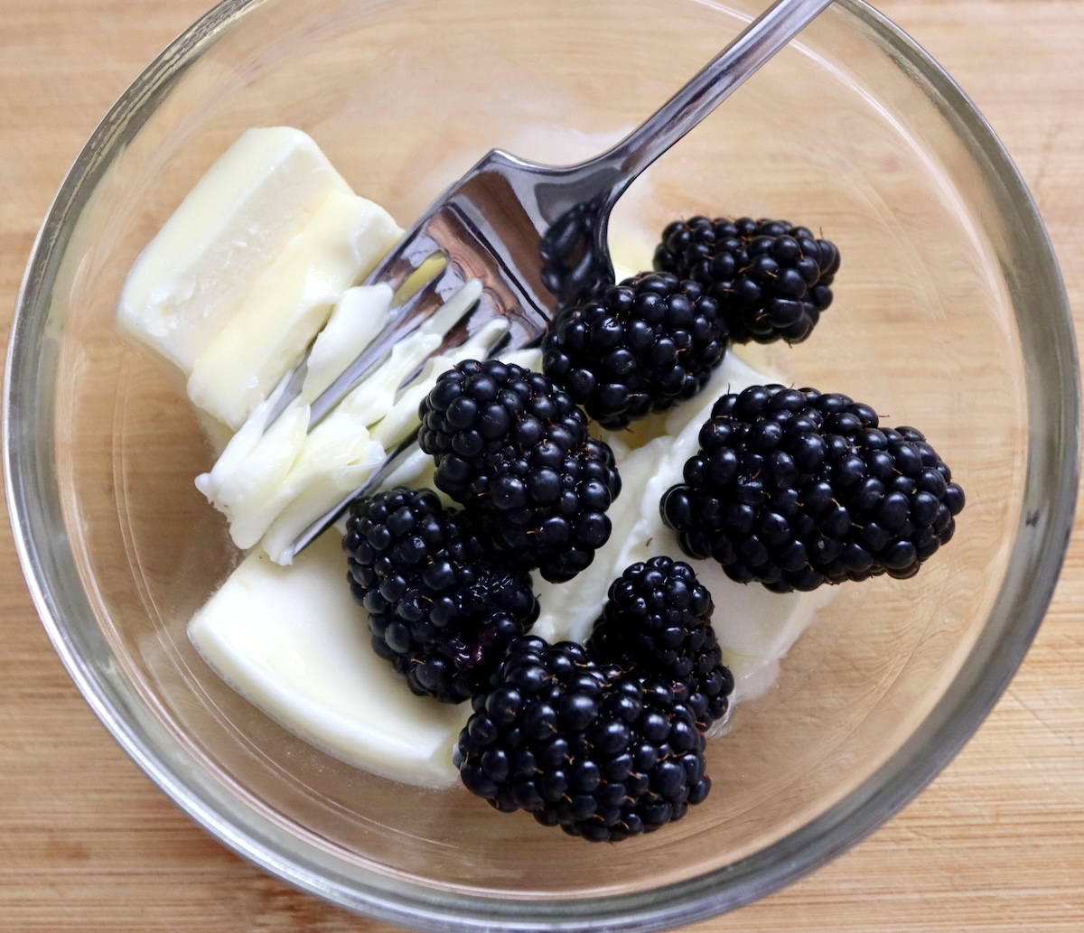 Blackberry-Chicken-Recipe-with-Blackberry-Butter) Butter with a fork and a few blackberries on top, in a glass bowl.