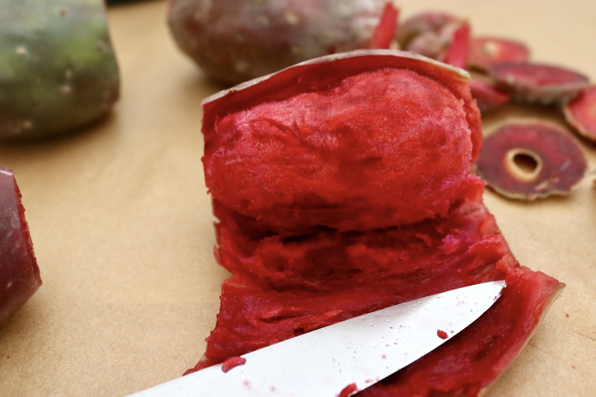 One prickly pear (cactus pear) with its skin almost all the way off.