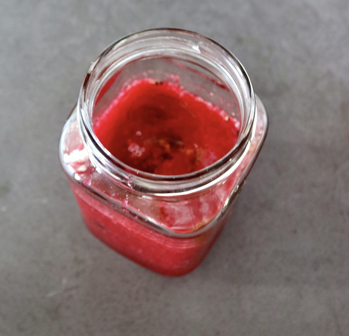 Prickly-Pear-Vinaigrette Jar about half full with prickly pear vinaigrette with no lid.