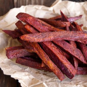 Small pile of purple French fries on crumpled parchment.