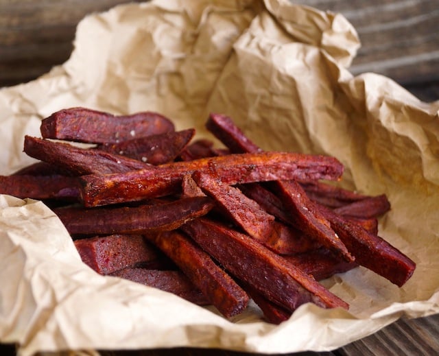 Chile-Lemon Roasted Purple Sweet Potato Fries on beige, crumpled parchment.