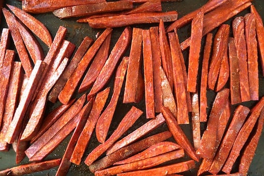 Roasted Purple French Fries on dark sheet pan.