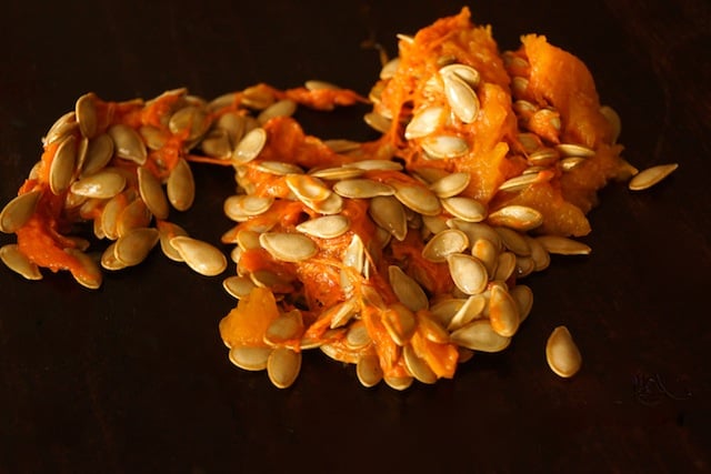 pile of butternut squash seeds with some of the orange flesh