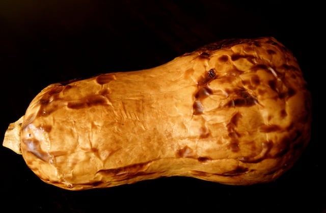 whole roasted butternut squash on black background