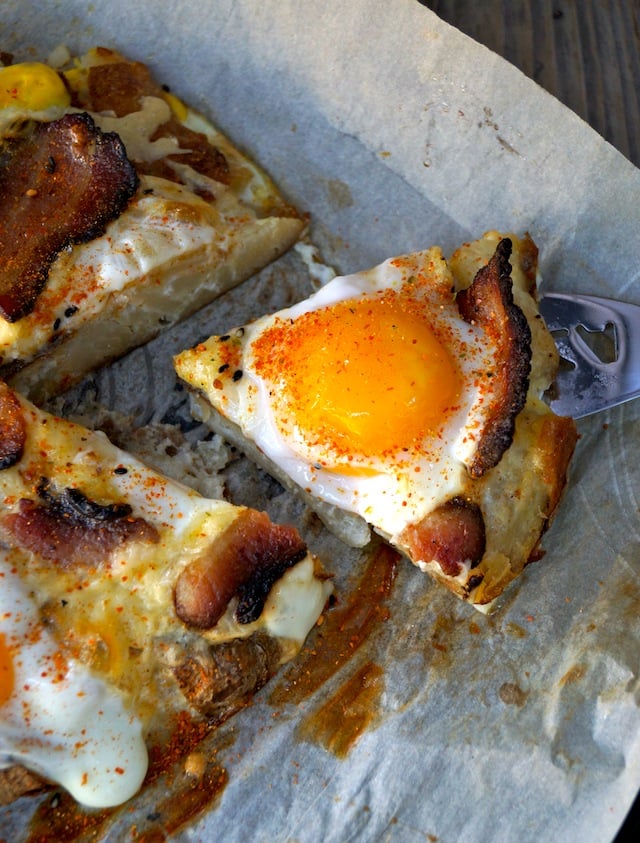 Breakfast Bacon and Eggs Smashed Potato Pizza, sliced on parchment