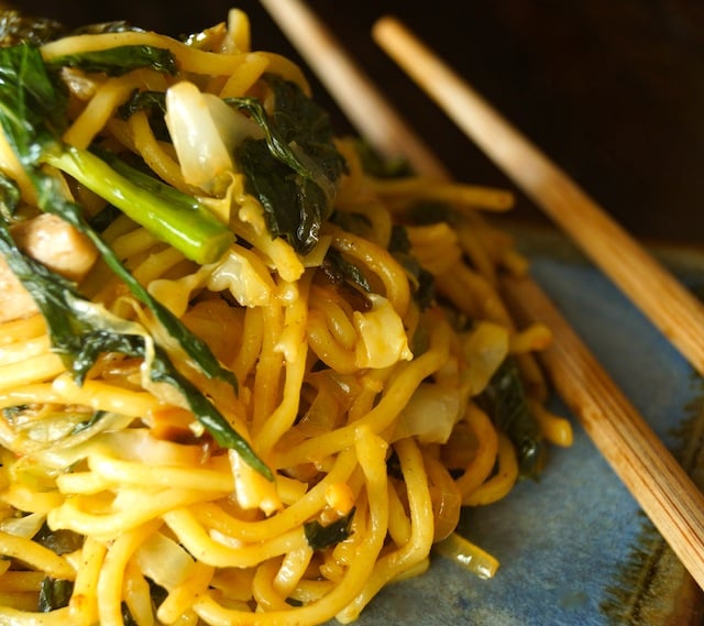 serving of Chinese Longevity Noodles with Gai Lan on ceramic plate with chopsticks