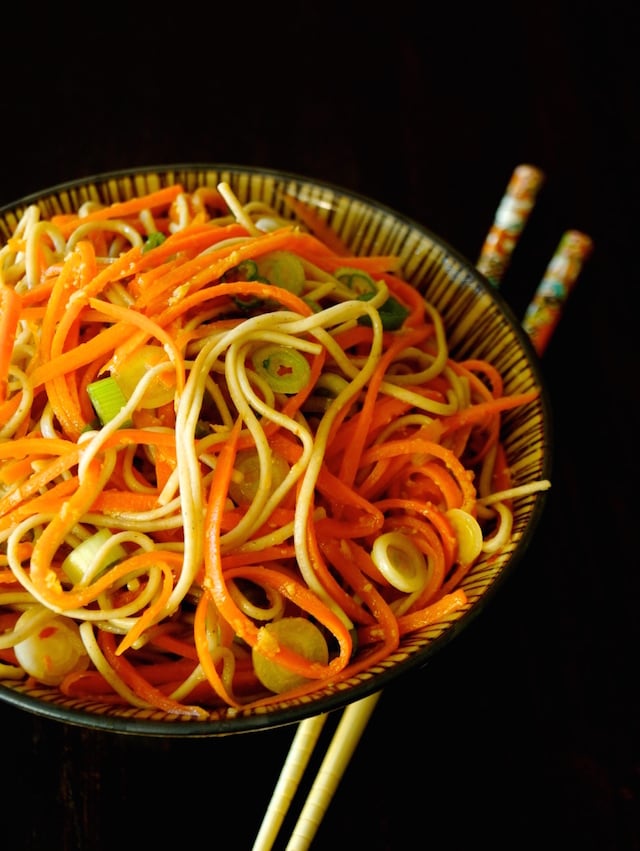 Carrot Ginger Soba Noodles in a brown, finely striped bowl with chopticks