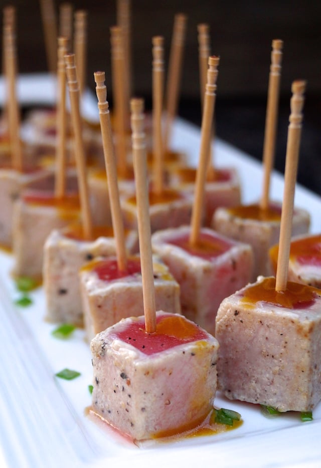 Wasabi Glazed Seared Ahi Appetizer with toothpicks on a white platter with chives