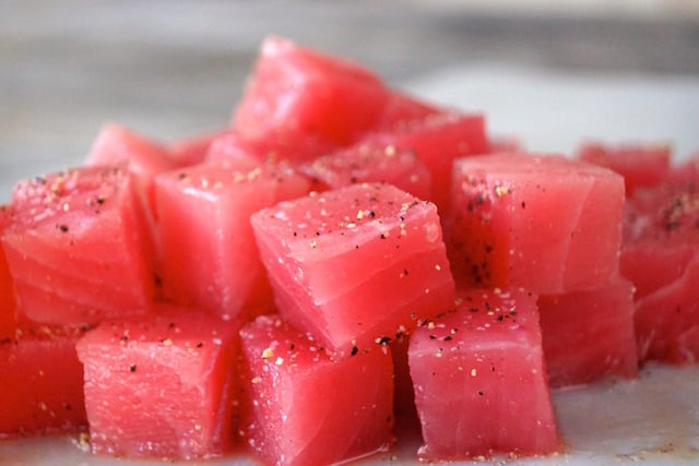 stack of bright pink, raw ahi tuna with pepper for Wasabi Glazed Seared Ahi Tuna Hors d'Oeuvre Recipe