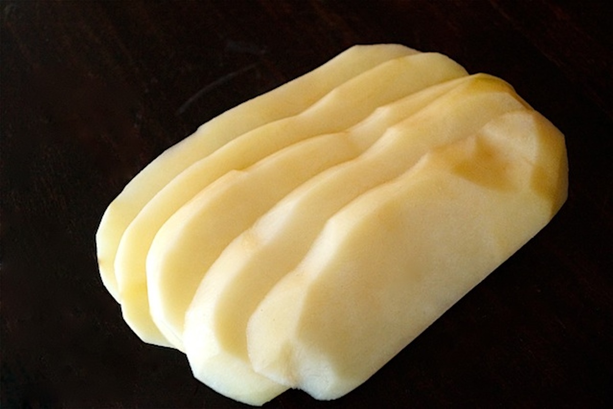 Several slices of raw Russet potato.