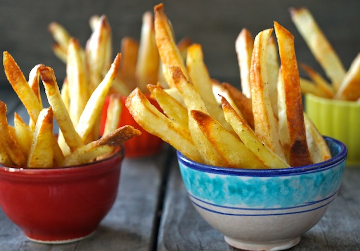 Three colorful ceramic bowls with oven roasted fries.