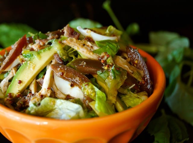 Close up of Shredded Chicken Cobb Salad with Citrus Vinaigrette in an orange bowl.