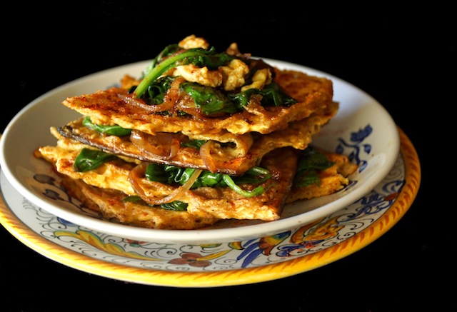 Side view of Matzo Brei à la Florentine recipe on a small white plate with pretty blue dish.