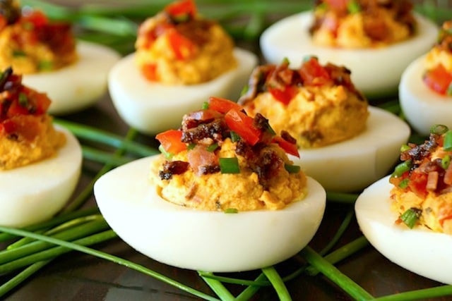 Several Bacon Chipotle Deviled Eggs with fresh chives