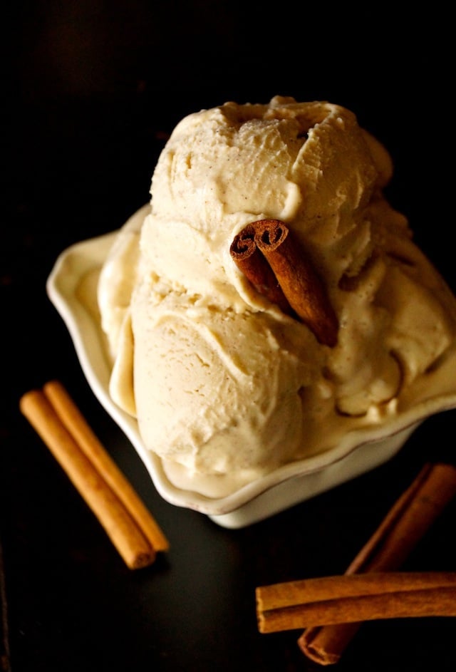 Cinnamon Ice Cream in a square, cream-colored dish with one cinnamon stick in the center and one on each side of the dish.