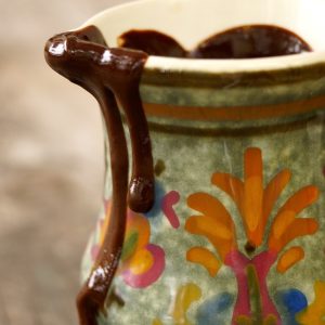 Espresso Chocolate Sauce Recipe in a pretty painted, cerammic pitcher, dripping over the side.