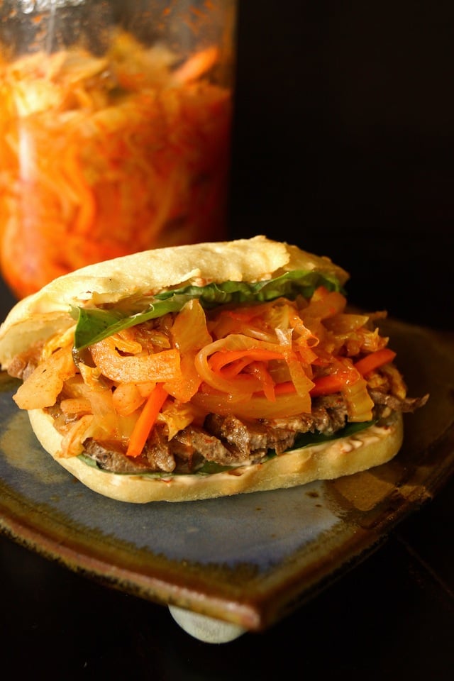 Steak-Kimchi Sandwich with Ginger Chile Aioli on a blue raised plate.