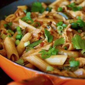 Orange sauté pan with penne pasta and poblanos