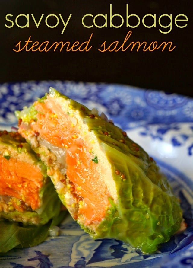 Cabbage Wrapped Salmon sliced in half on a blue plate.