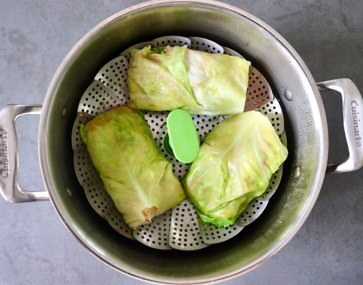 Salmon-and-Cabbage-Recipe Three salmon-filled cabbage rolls in a steamer pot.