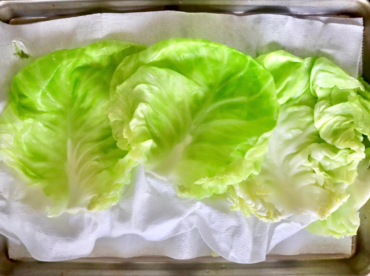 Salmon-and-Cabbage-Recipe Layers of blanched cabbage leaves on paper towels on a sheet pan.