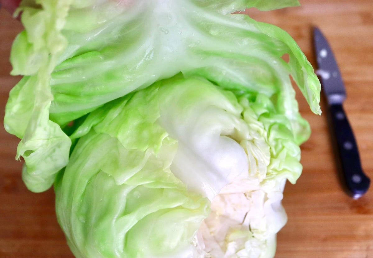 Salmon-and-Cabbage-Recipe Cabbage leaf being pulled away from head of cabbage.