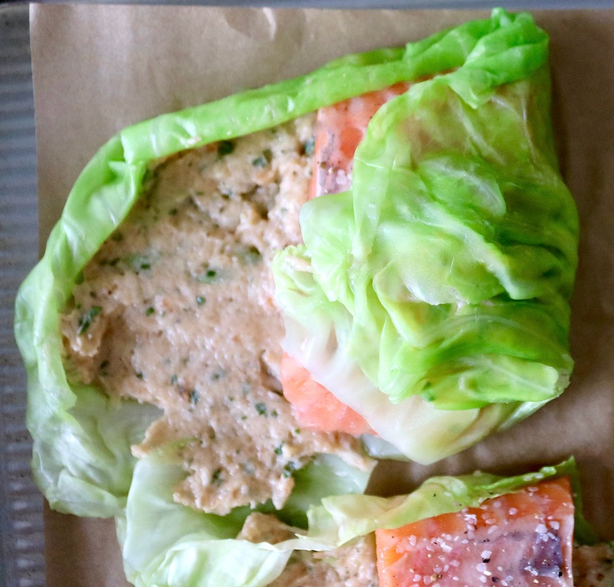 Salmon-and-Cabbage-Recipe One cabbage leaf with salmon mousse being rolled over a fillet of salmon.