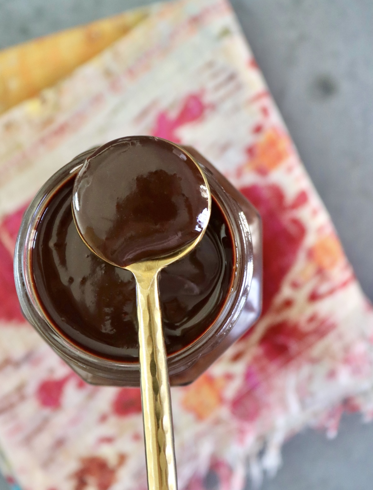 Espresso-Chocolat-Sauce-Recipe Jar with espresso chocolate sauce, with a gold spoon resting on top.