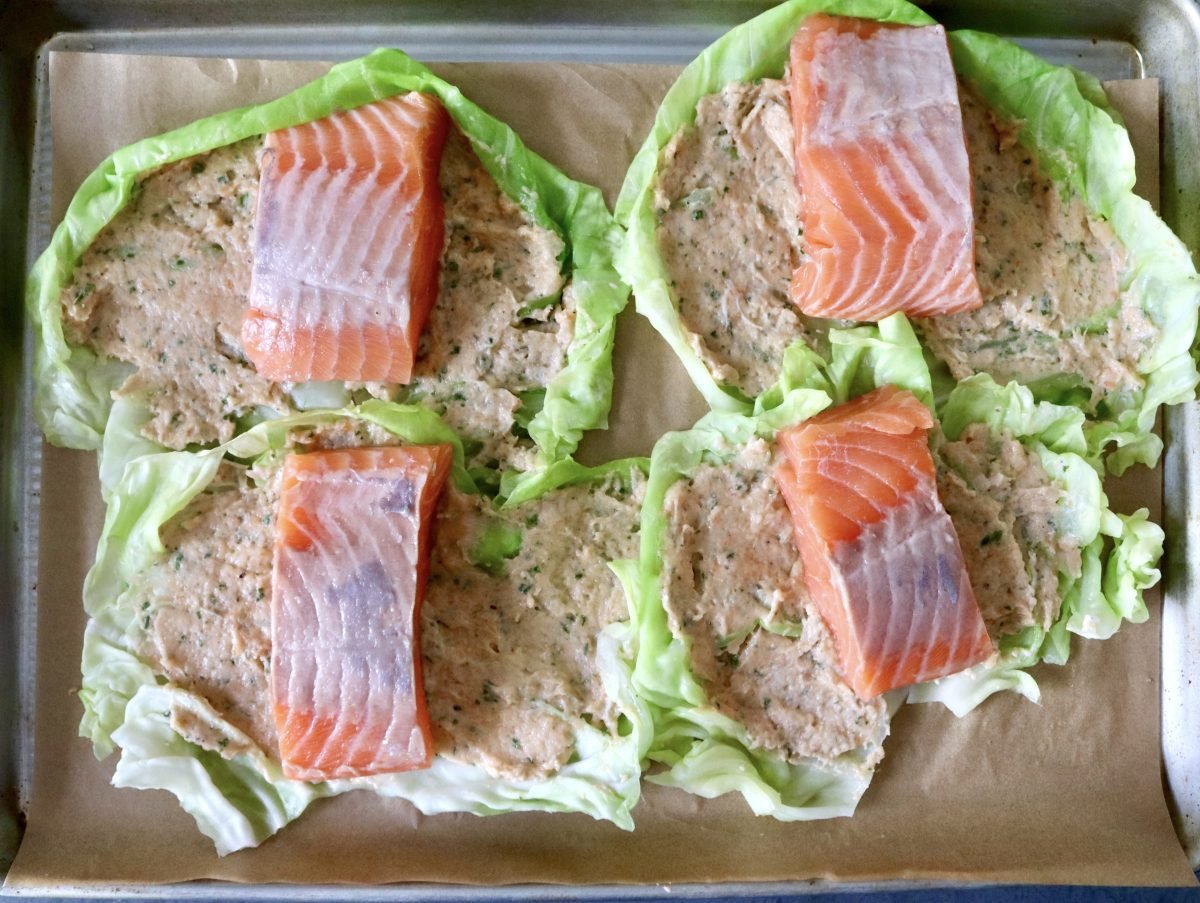 Salmon-and-Cabbage-Recipe Four cabbage leaves spread with salmon mousse, with a salmon fillet on top.