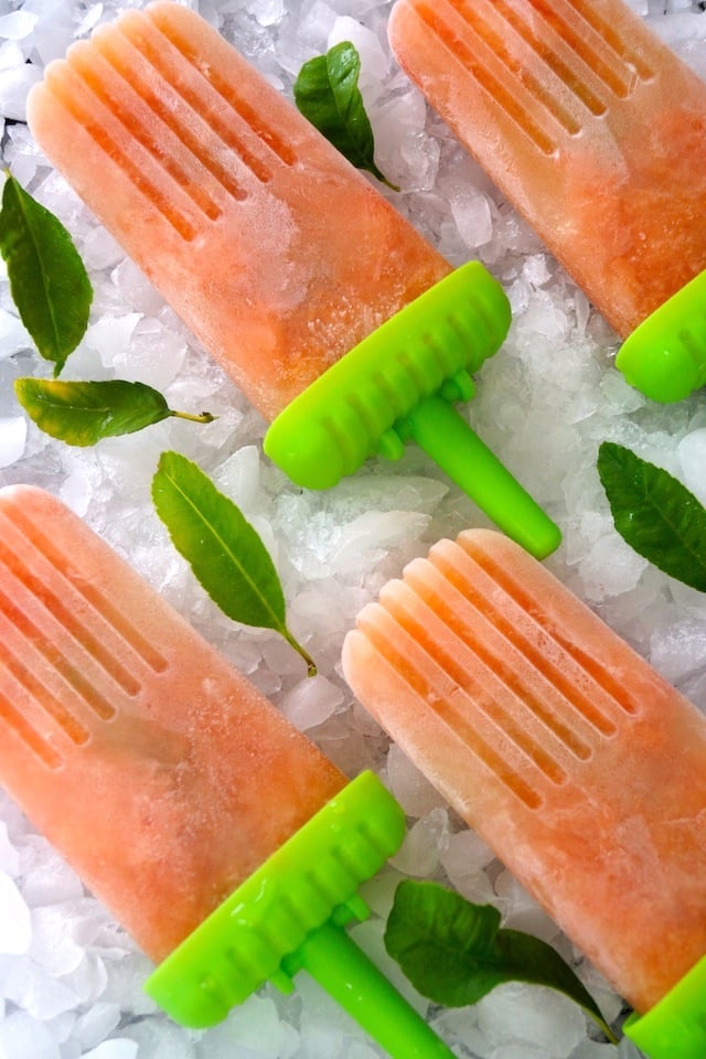 Honey Grapefruit Popsicles on crushed ice with lemon leaves.