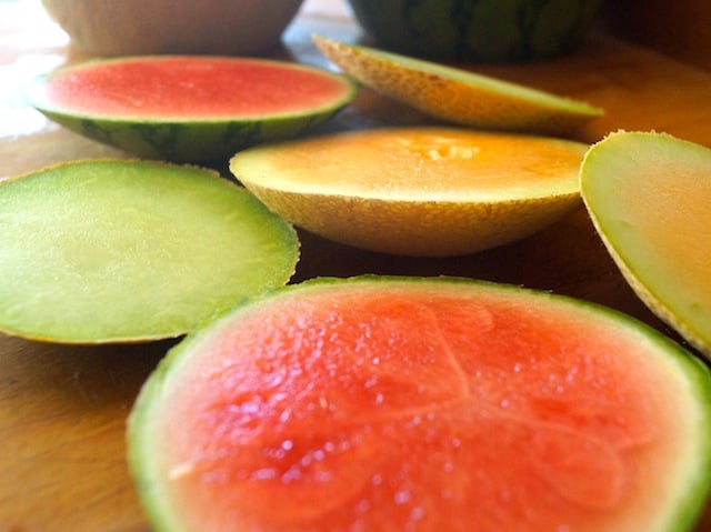 Melon slices in varying colors on cutting board