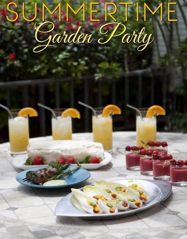 Summertime Garden Party Menu spread out on outdoor table with 4 tall glasses or a yellow beverage with orange slices on the rims.