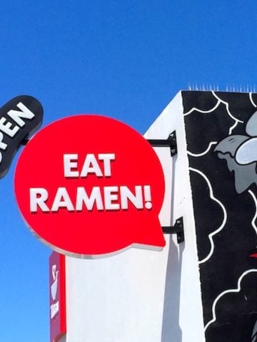 mural of dragon and open sign on the outside of Tatsu Ramen Restaurant in Los Angeles.