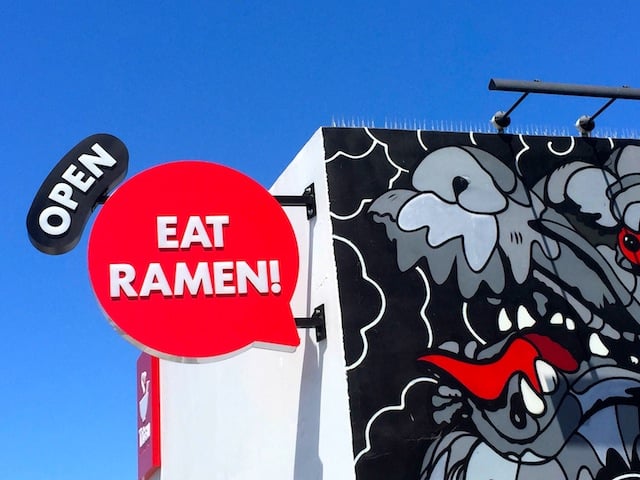 mural of dragon and open sign on the outside of Tatsu Ramen Restaurant in Los Angeles.